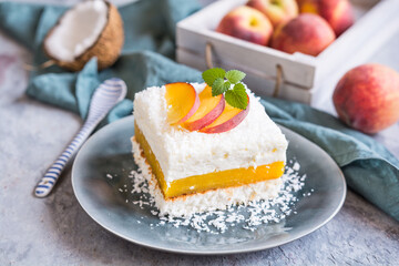 Coconut dessert with peach filling, topped with fresh fruit slices