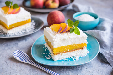 Coconut dessert with peach filling, topped with fresh fruit slices