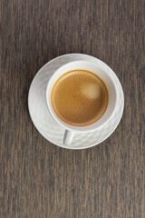 Black coffee in a white mug on the table. Flat lay.