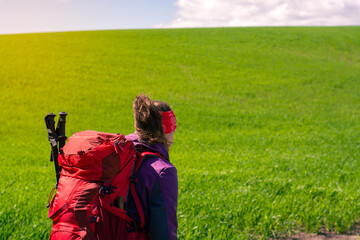 Woman hiking alone with red hiking backpack