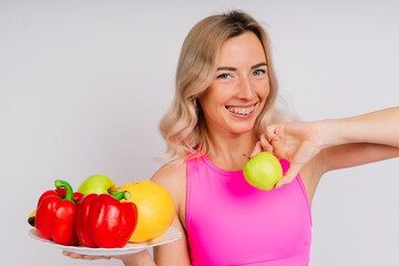 Healthy eating, happy woman with fruits and vegetables is eating apple