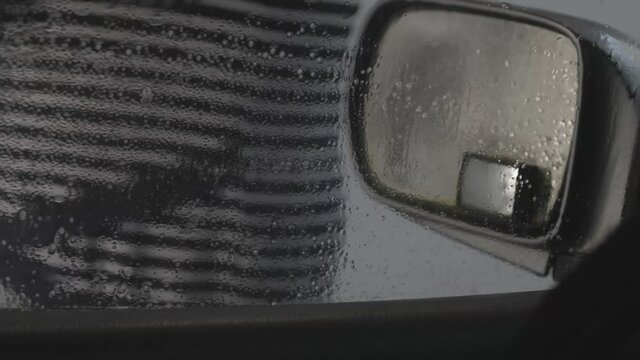 Person At Carwash Walking Past A Car Window Covered In Suds