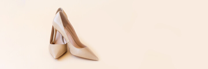 Classic beige women high heel shoes on pastel background. Minimal female background, banner. Fashion blog and sale concept.