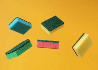 Kitchen dish washing sponge on yellow background. Minimal balance composition. Cleaning home concept.