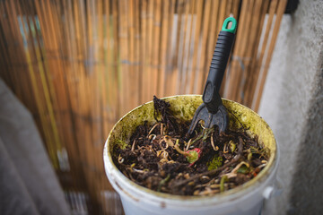 An open container with topped compost on the apartment balcony. 