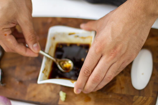 Top View Of A Man Making A Soy Sauce In A White Plate