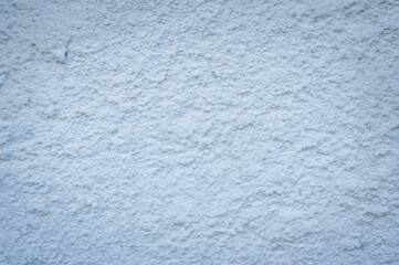 Rough textured background of bluish-white color taken from a facade, from a wall.