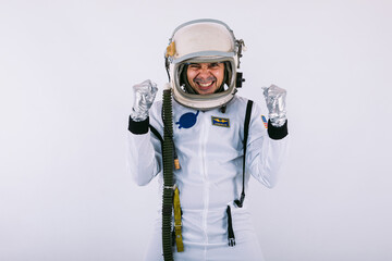Male cosmonaut in spacesuit and helmet, clasping hands in a sign of joy and strength, on white background.