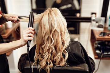Beautiful hairstyle of blond middle-aged woman in modern hair salon... - obrazy, fototapety, plakaty