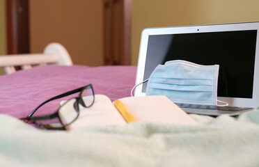 Work space in the bed at home during coronavirus outbreak. Quarantine or lockdown at home.