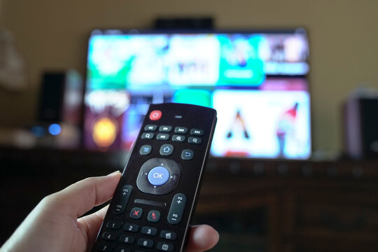 Person changing tv programs by using smart tv remote control. Close up view.