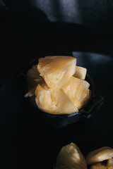 Pineapple slice under sunlight in dark background. Tropical fruits. Top view. Free space for text.