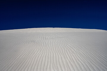 Fototapeta na wymiar Bright White Sand Dunes with Deep Blue Sky