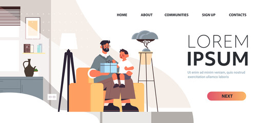 young father holding gift box for son parenting fatherhood concept dad giving holiday present to his kid at home