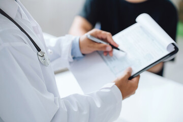 doctor holding test results and consulting patient at desk medical office,  Hospital/ clinic...