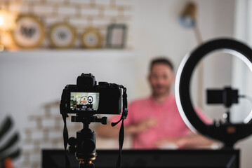 detrás de cámara de un hombre siendo entrevistado con luces y micrófonos para un blog