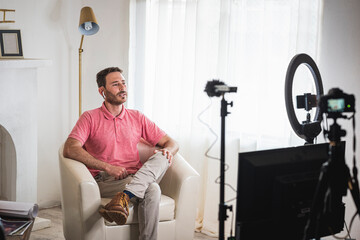 detrás de cámara de un hombre siendo entrevistado con luces y micrófonos para un blog