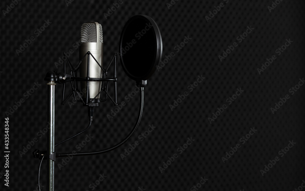 Micro à condensateur dans un studio d'enregistrement sombre