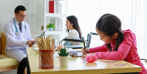 Cheerful girl with mother and doctor in office