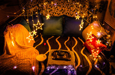 decorated living room for celebration at night with fairly lights and cushions