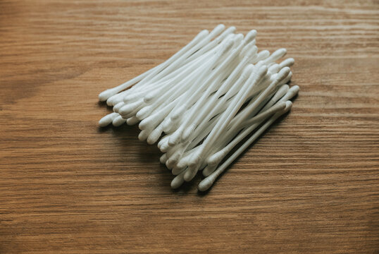 White cotton buds isolated on wooden background.
