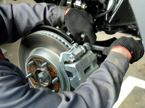 Front brake disc, brake pads assembly, brake caliper close-up.Spare parts.Monitoring of the technical condition, checking the safety of operation of the car.Maintenance in the service center.