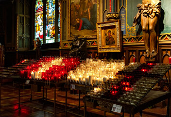 Fototapeta na wymiar Small Candles burning inside the famous Notre-Dame Basilica, Quebec, Canada.