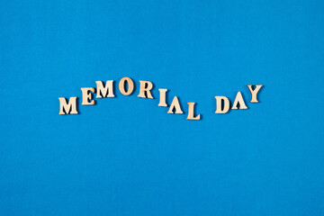Memorial Day text made from wooden letters on blue background