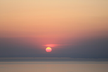 sunset view. Cloudy sky, sea and red sun