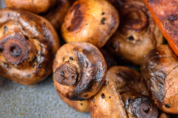 A close view of grilled button mushrooms on a blue plate