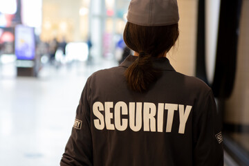 Rearview of a female security guard  in a uniform patrolling a residential area