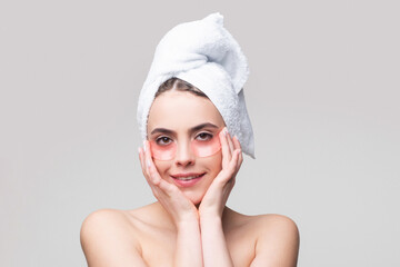 Woman applying eye patches. Portrait beauty girl with towel on head.