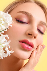 Fototapeta premium Beautiful young woman with hyacinth flowers on color background, closeup