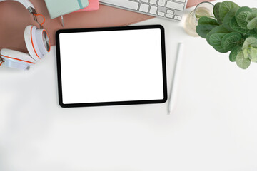 Mock up digital tablet, stylus pen, houseplant and headphone on white table.
