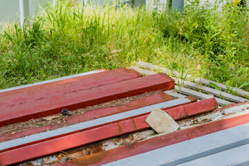 Metal construction beams laying on ground in tall grass.