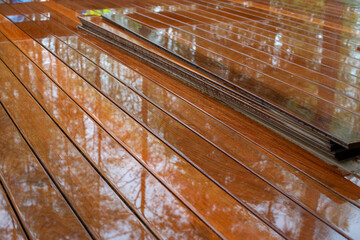 Naklejka na ściany i meble Ipe wood plank terrace on rainy day.