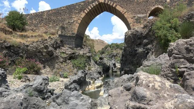 Medieval bridge of Adrano, Sicily, of arabic origin and saracen. Called Simeto river  lava gorges. Video 4k
