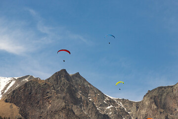 Fototapeta na wymiar paragliders fly among the mountains