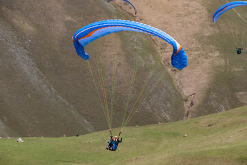 paragliders fly among the mountains