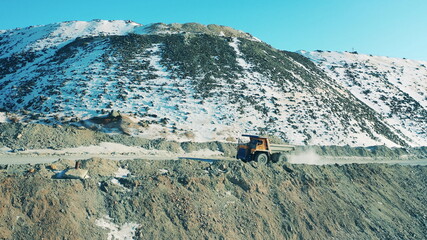 Snowy copper mine with a truck riding along it