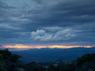 A view of a large mountain under gloomy sunset clouds in the sky background cloudy wallpaper 