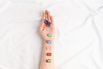 Healing reiki chakra crystals on woman's hands. Gemstones for wellbeing, meditation, relaxation - obrazy, fototapety, plakaty