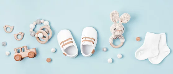 Fototapeten Baby shoes and teethers banner. Organic newborn accessories, branding, small business idea. © netrun78