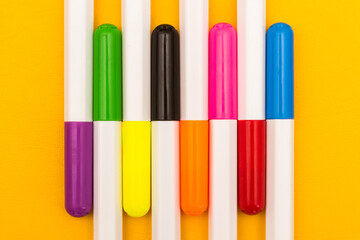 Multicolored markers on a yellow background. Photo for drawing with felt-tip pens.