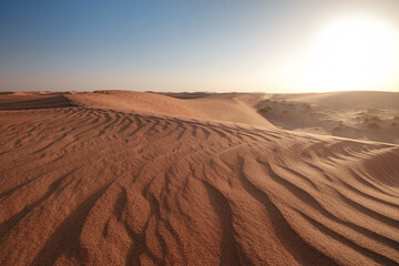 Sunset over the sand dunes in the desert.