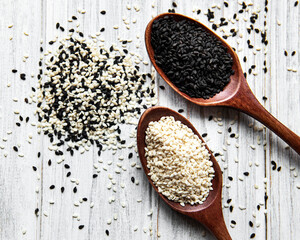 Black and white sesame seeds in a spoons