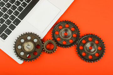 cogwheels, gears and laptop on color background top view. concept of computer repairing or maintenance