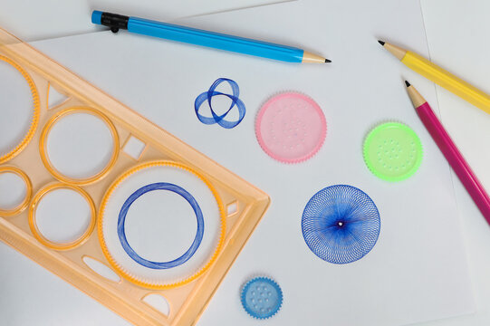 Spirograph ruler on white background. Drawing the spirograph pattern on white paper. 