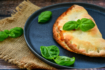 Home made italian calzone vegetarian  pizza with  tomatoes, mozzarella and parmesan cheese and fresh basil 
