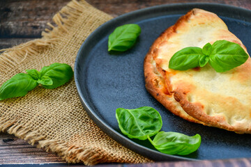 Home made italian calzone vegetarian  pizza with  tomatoes, mozzarella and parmesan cheese and fresh basil 